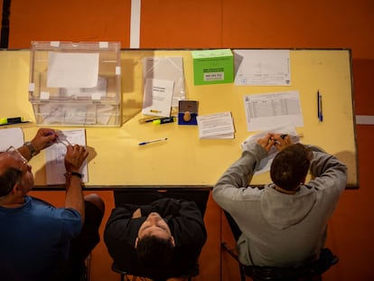 Los componentes de una mesa electoral esperan a que los ciudadanos voten en la Escola Grèvol (Barcelona).