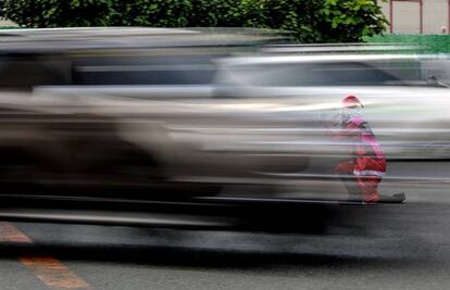 El oficial de tráfico filipino Ramiro Hinojas, vestido con un disfraz de Papá Noel, dirige a los automovilistas en una calle de Pasay City. Hinojas baila mientras trabaja para hacer más soportable el tráfico en las intersecciones más concurridas de Metro Manila durante las horas punta. El tráfico vial suele congestionarse más en diciembre, a medida que aumenta el número de personas que hacen sus compras navideñas.