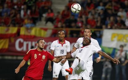 Koke pelea un balón con jugadores costarricenses.