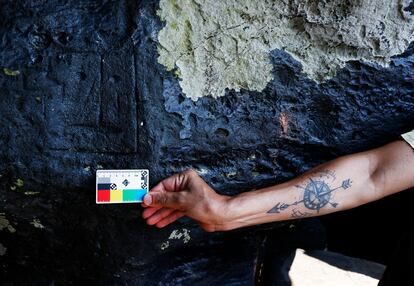 Un arqueólogo mide pinturas rupestres en el sitio arqueológico de Ponta das Lajes.