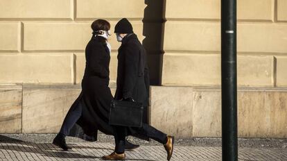 Un hombre con una mascarilla pasa por delante de una mujer, el pasado 23 de marzo en Praga.