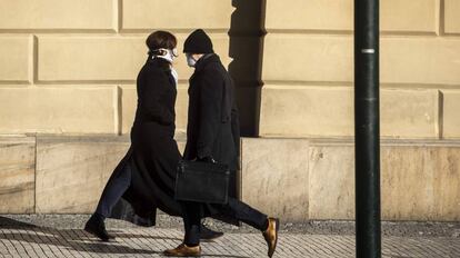 Un hombre con una mascarilla pasa por delante de una mujer, el pasado 23 de marzo en Praga. 