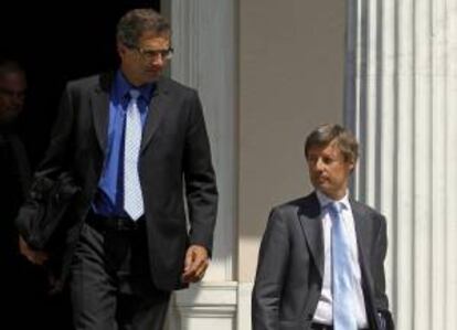 El jefe de misión del Banco Central Europeo (BCE), Klaus Masuch (i), y el de la Comisión Europea, Matthias Morse (d), abandonan la oficina del primer ministro griego, Andonis Samaras, tras su encuentro en Atenas (Grecia), el pasado jueves 4 de julio de 2013.