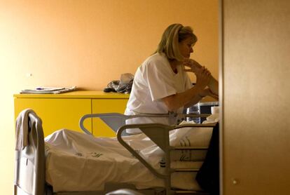 Un enfermo terminal recibe cuidados de una enfermera.