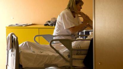 Un enfermo terminal recibe cuidados de una enfermera. 