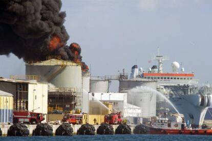 Un barco participa en la extinción del fuego declarado en un depósito de Gibraltar.