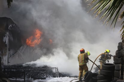 Los bomberos apagan un incendio en un almacén de neumáticos en Elche.