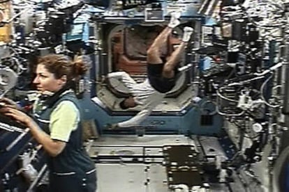 Anousheh Ansari trabaja en uno de los ordenadores del laboratorio Destiny de la ISS mientras el estadounidense de origen español, Miguel López Alegría, flota al fondo