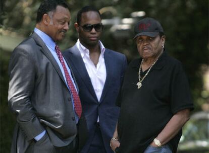 Jesse Jackson, junto a su hijo Yusef DuBois Jackson, habla con el padre de Michael Jackson en la casa de la familia del artista