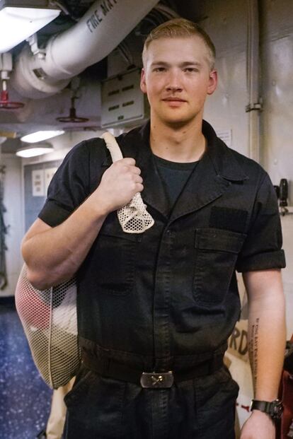 Un marinero del USS Truman, retratado en uno de los innumerables corredores del portaviones que convierten el interior del buque en un hormiguero.