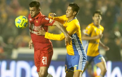 Triverio (i) protege el balón ante la marca de Hugo Ayala
