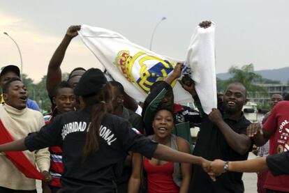 Un grupo de aficionados guineanos exhibe una bandera del Real Madrid a la llegada de la selección española al aeropuerto de Malabo.