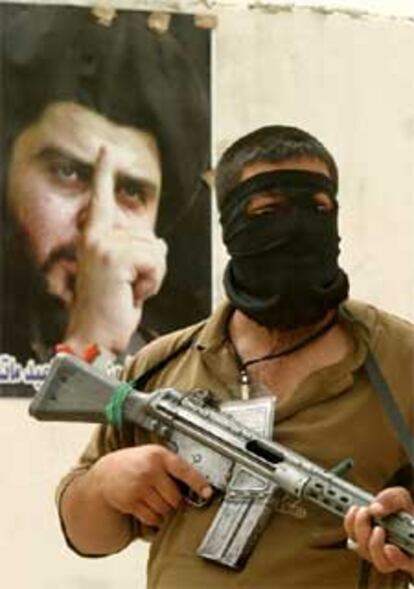 Un miliciano monta guardia ante la oficina en Bagdad de Al Sáder,a quien EE UU quiere vivo o muerto.