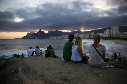 Turistas disfrutan de la puesta de sol en la playa de R&iacute;o de Janeiro