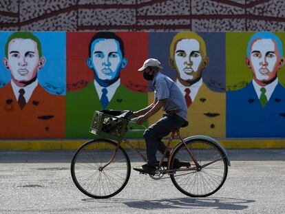 Un hombre monta en bicicleta delante de unos grafitis de Hugo Chávez en Barinas este 7 de enero.