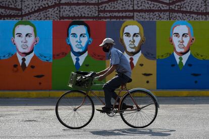 Un hombre monta en bicicleta delante de unos grafitis de Hugo Chávez en Barinas este 7 de enero.