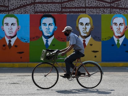 Un hombre monta en bicicleta delante de unos grafitis de Hugo Chávez en Barinas este 7 de enero.