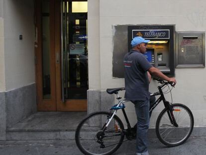 Un hombre usa un cajero situado en la calle