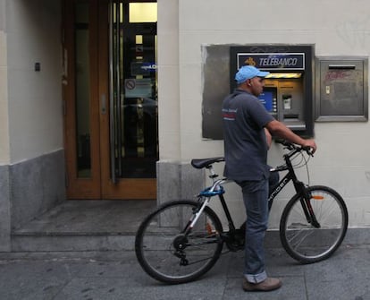 Un hombre usa un cajero situado en la calle