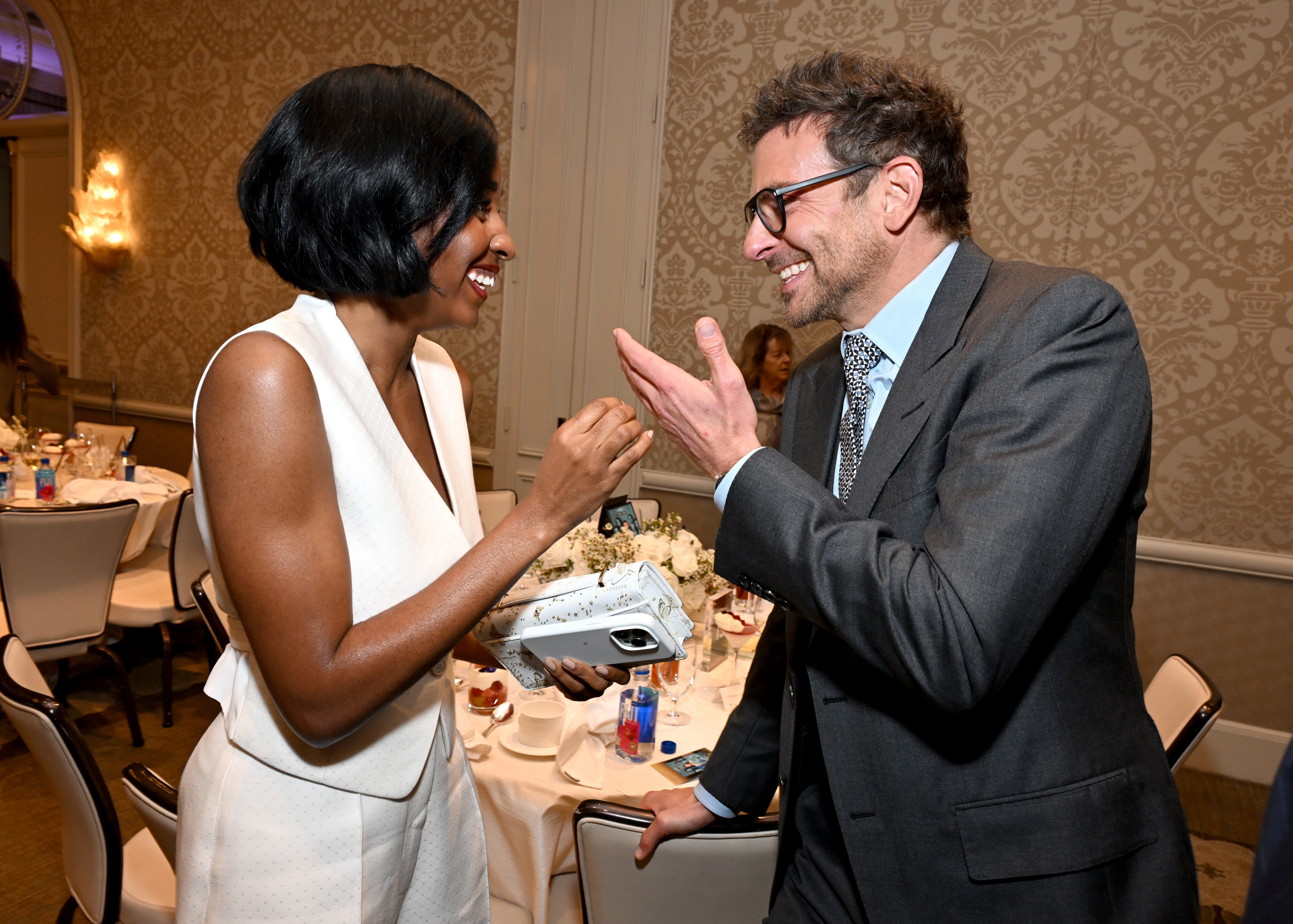 Ayo Edebiri charla animadamente con el actor Bradley Cooper en los AFI Awards, celebrados en el Four Seasons de Beverly Hills, el 12 de enero de 2024. 