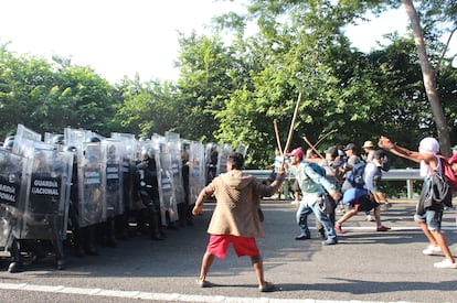 Un grupo de migrantes que viajan en caravana, se enfrentan con integrantes de la Guardia Nacional hoy en la población de Pijijiapan, en Chiapas