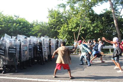 Un grupo de migrantes que viajan en caravana, se enfrentan con integrantes de la Guardia Nacional hoy en la población de Pijijiapan, en Chiapas