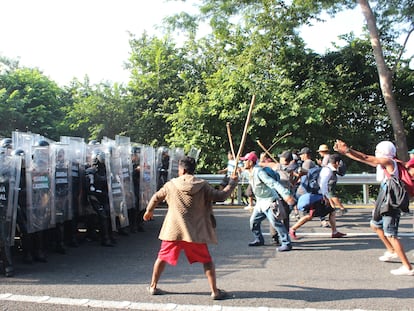 Un grupo de migrantes que viajan en caravana, se enfrentan con integrantes de la Guardia Nacional hoy en la población de Pijijiapan, en Chiapas.