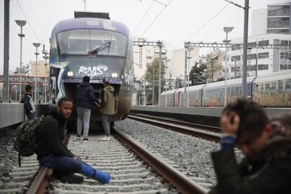 Más de cien personas han ocupado las vías de la estación central de Atenas para manifestarse contra el control policial que les ha impedido unirse a una caravana de migrantes para cruzar ilegalmente la frontera con Macedonia del Norte. En la imagen, varias personas bloquean la vía férrea en la estación central de Larissis, el viernes 5 de abril de 2019.