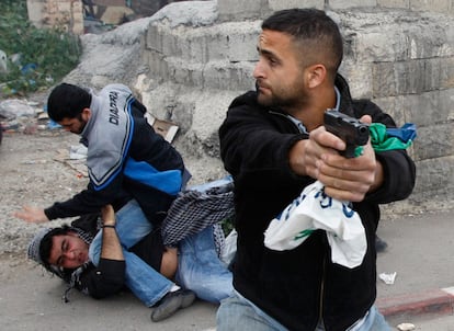 Un policía israelí de paisano apunta su arma, al tiempo que otros detienen a un palestino en Wadi al-Joz, Jerusalén, en los choques entre la policía y los manifestantes palestinos.