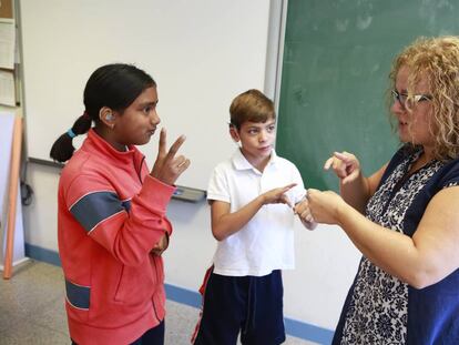 Una responsable de lenguaje de signos con dos niños de cuarto de primaria en 2015.