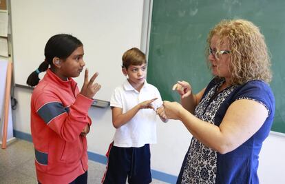 Una responsable de lenguaje de signos con dos niños de cuarto de primaria en 2015.