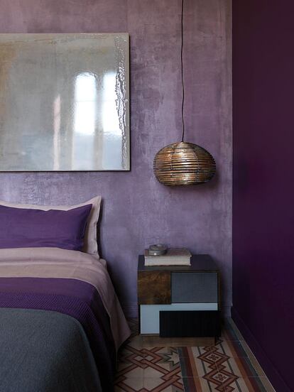 Tonos intensos. En el dormitorio, dominado por el color púrpura, la cama es el modelo Trevor (Baxter), y la mesilla, otro diseño de Obradovic y Basedow. Este último firma también el lienzo sobre el cabezal de la cama. La lámpara de suspensión es de Angela Ardisson (Artplay).