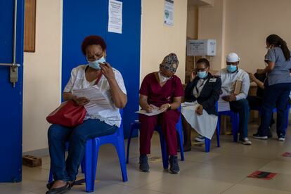 Maggie Sedidi (izquierda), enfermera del hospital Chris Hani Baragwanath de Soweto, rellena un cuestionario médico antes de recibir su dosis de la vacuna Johnson & Johnson contra la covid-19 en un centro de vacunación en Soweto, Sudáfrica, el viernes 5 de marzo de 2021.