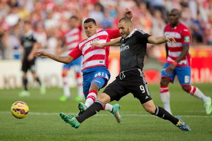 Karim Benzema dispara a puerta y marca el tercer gol para el Real Madrid mientras Jeison Murillo del Granada trata de impedirlo sin &eacute;xito. 