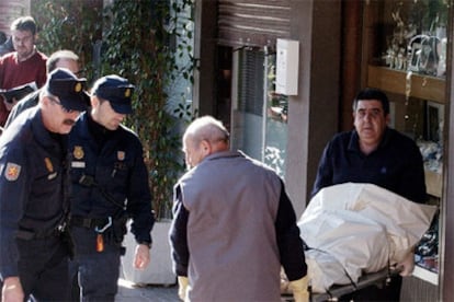 Miembros de la funeraria trasladan a una de las tres personas asesinadas en un atraco  a una joyería de Castelldefels.