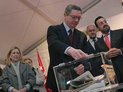 Gallardón coloca periódicos en una urna de inauguración en un centro de la ONCE