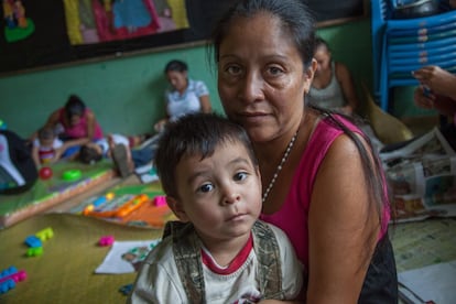 Santa Teresa es una pequeña comunidad en San Martín, un área municipal en San Salvador, en El Salvador. En la escuela primaria se está desarrollando un programa gracias al que los padres pueden dejar a los niños en edad escolar y llevar a sus bebés más pequeños a los talleres que forman parte del programa de crianza de Triple E. Aquí los padres aprenden sobre la salud física y emocional de los niños, la importancia de la disciplina no violenta y cómo comunicarse de manera saludable. Las familias se apoyan mutuamente. en la imagen, una de las beneficiarias, Reina, de 45 años y  madre de tres hijos de 13, seis y tres años.