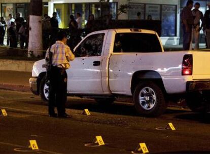 Un policía observa la escena del crimen donde un hombre murió tiroteado.