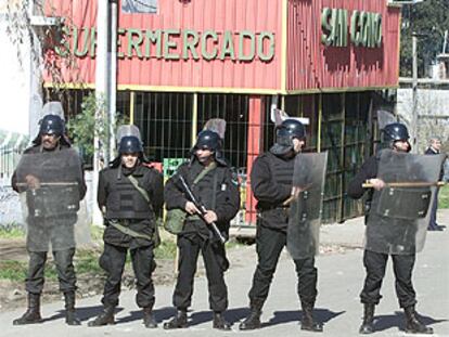 La policía uruguaya protegía ayer la entrada a un supermercado para evitar más saqueos.