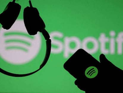 FILE PHOTO: A smartphone and a headset are seen in front of a screen projection of Spotify logo, in this picture illustration