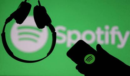 FILE PHOTO: A smartphone and a headset are seen in front of a screen projection of Spotify logo, in this picture illustration