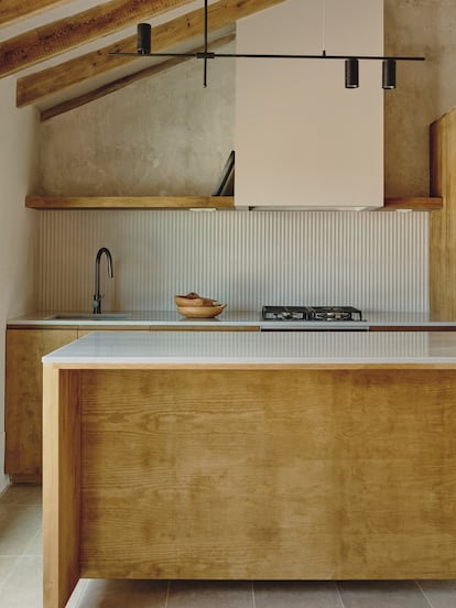 La cocina, de líneas rectas y madera de pino, supone casi el único elemento contemporáneo en la habitaición como vivienda de la bodega.