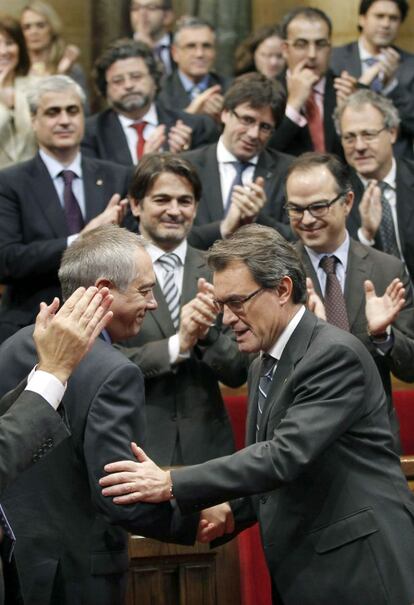 El líder de CiU, Artur Mas, es felicitado por el primer secretario del PSC, Pere Navarro, tras haber sido reelegido presidente de la Generalitat de Cataluña gracias a los votos de ERC, en el pleno del Parlament.