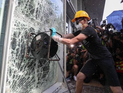 Manifestante tenta quebrar janela do Parlamento em Hong Kong, nesta segunda-feira.