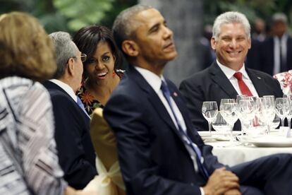 La primera dama de los Estados Unidos Michelle Obama conversa con el presidente de Cuba Raúl Castro ante la presencia de Barack Obama, en una cena en el Palacio de la Revolución.