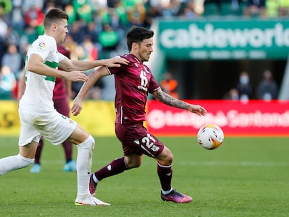 David Silva (d) protege el balón ante Gerard Gumbau, del Elche, durante el partido (1-2) disputado este domingo en el estadio Martínez Valero.