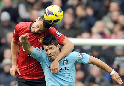 Rio Ferdinand lucha por el balón con Sergio Aguero.