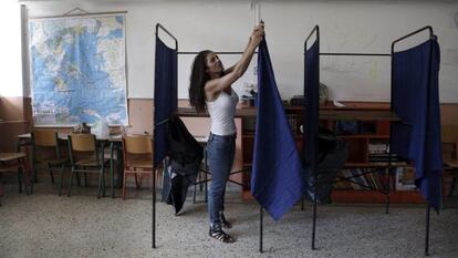Una funcionària col·loca una cabina en un col·legi a Atenes.