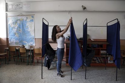 Una funcionaria coloca una cabina en un colegio en Atenas.