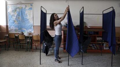 Una funcionaria coloca una cabina en un colegio en Atenas.